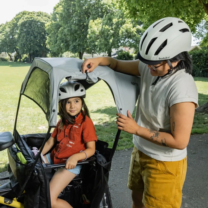 Electric cyclist with helmet and child on a Komut Bikes bicycle
